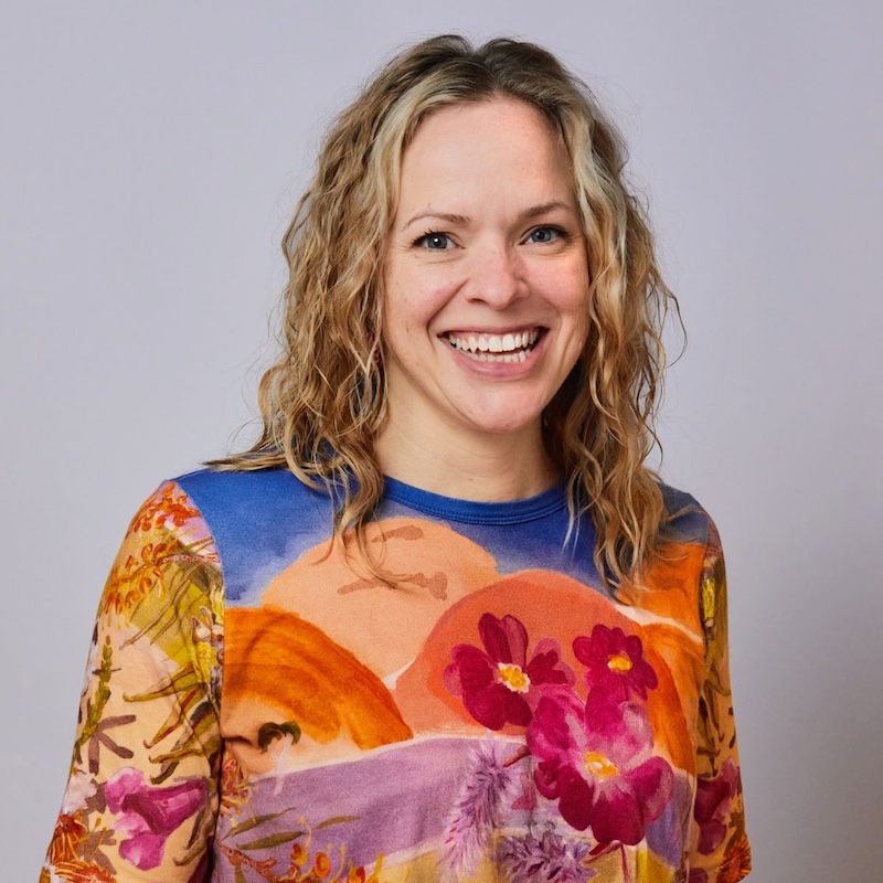 A smiling Kimberley wearing a colouful shirt.