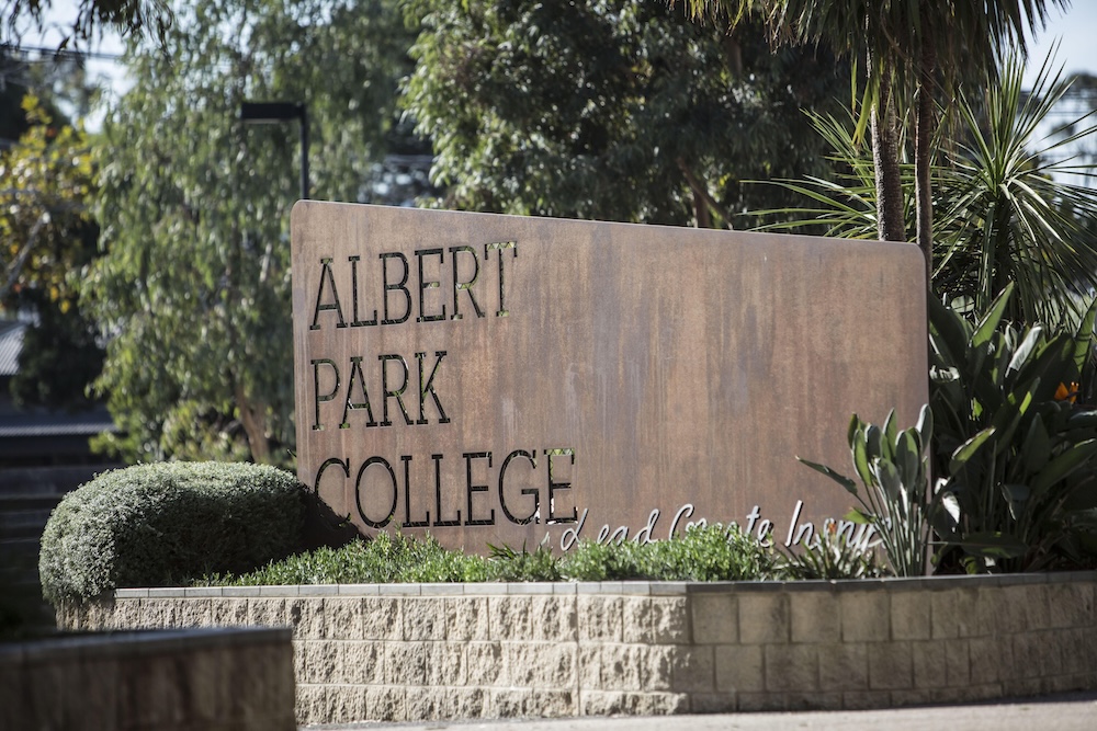 Sign with Albert Park College etched surrounded by bush